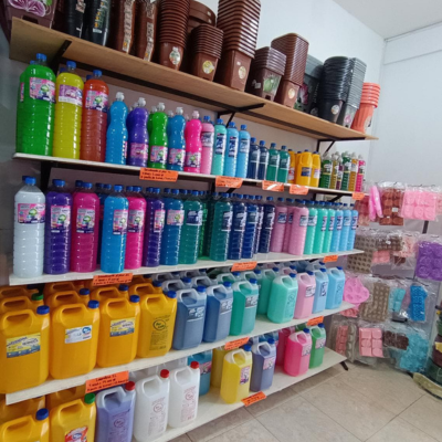 Estante de almacén con botellas y bidones de detergente de colores
